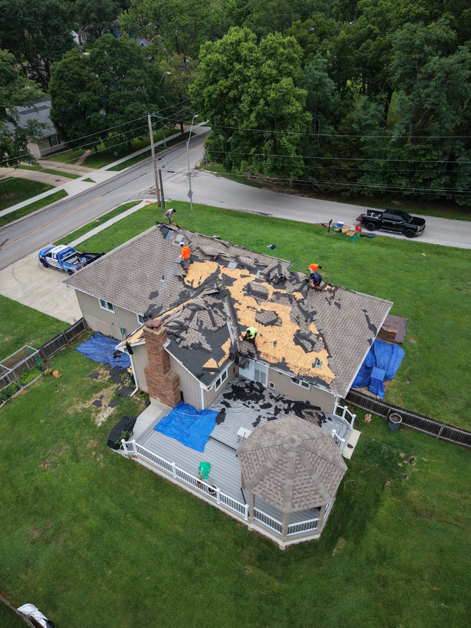 Aerial view of the AGR Roofing crew tearing off and replacing the roof on a two story Kansas City home.